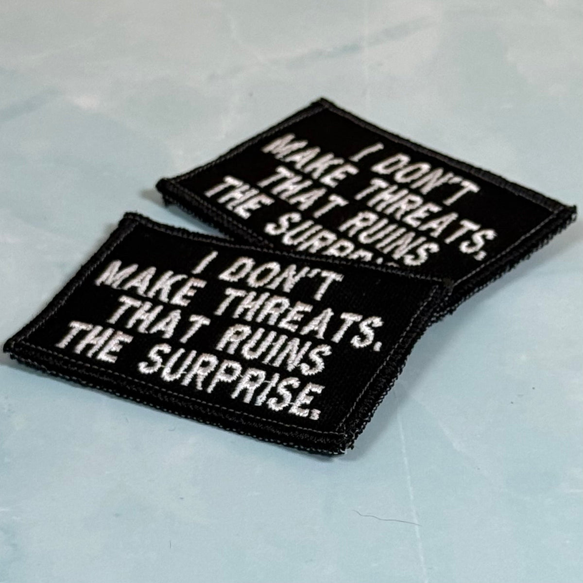 I Don't Make Threats, That Ruins The Surprise Funny Morale Patch, 2x3" | Made in USA | VELCRO® Brand Hook Backing