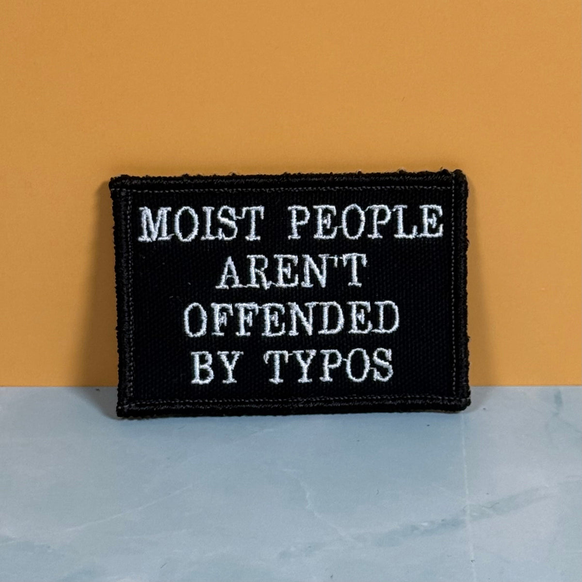Moist People Aren’t Offended by Typos Funny Morale Patch, 2x3" | Made in USA | VELCRO® Brand Hook Backing